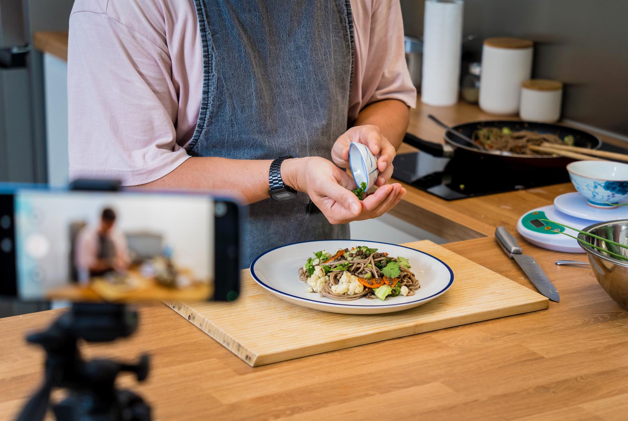 Instructor arranging plated dish in cozy kitchen